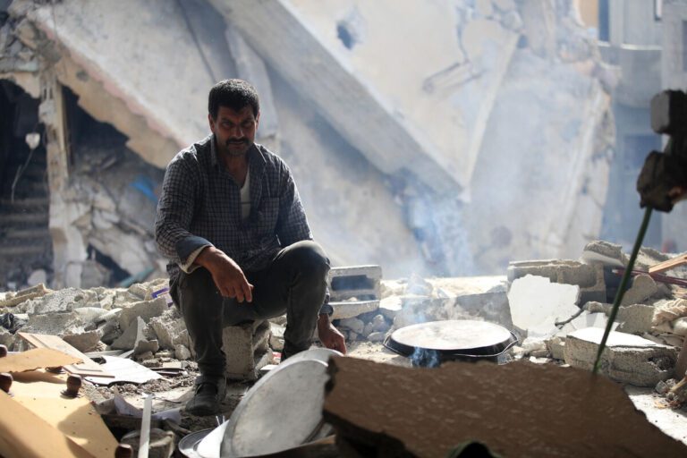 Man sitting in bombed out area in Gaza